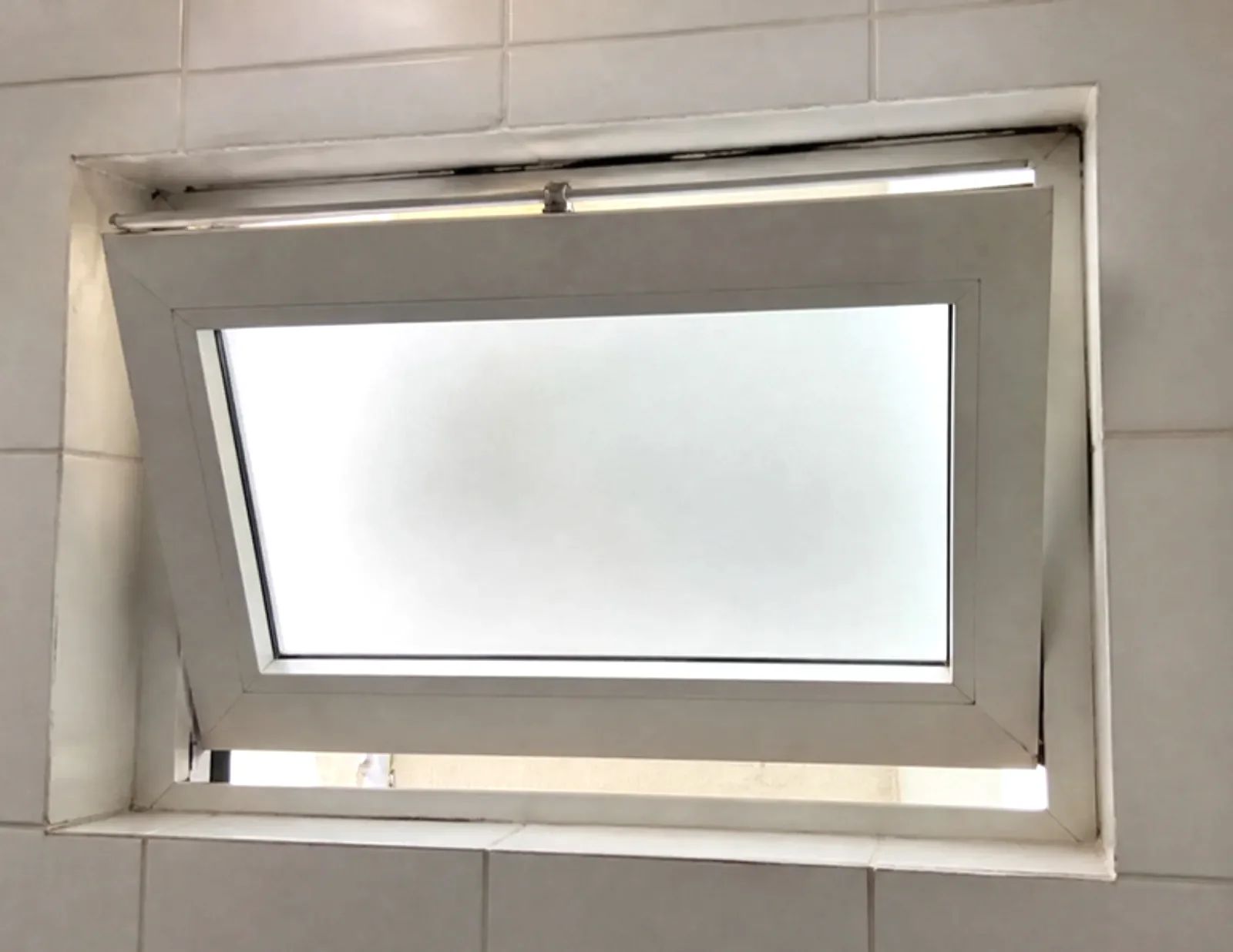 חלון אמבטיה עם זכוכית חלבית, פתוח בהטיה